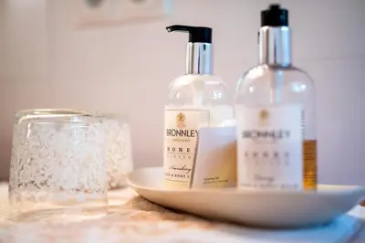two bottles of soap and a glass on a table at Mitterstiller in Auna di Sotto