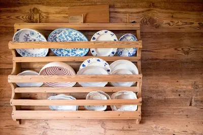 a wooden shelf filled with plates and bowls at Mitterstiller in Auna di Sotto