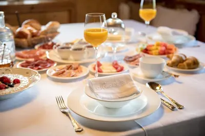 a table with plates of food and glasses of orange juice at Mitterstiller in Auna di Sotto
