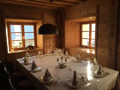 a dining room with a long table in a room with windows at Mitterstiller in Auna di Sotto