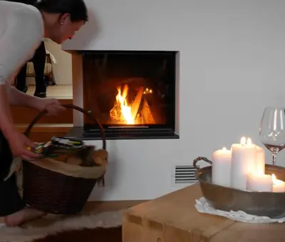 a woman is standing in front of a fireplace at Mitterstiller in Auna di Sotto