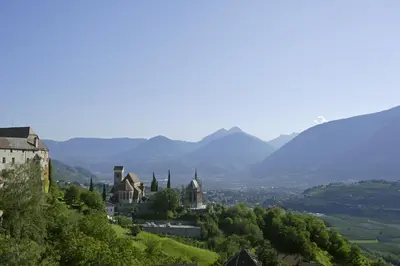 a town on a hill with mountains in the background at Hotel Garni Lichtenau in Schenna