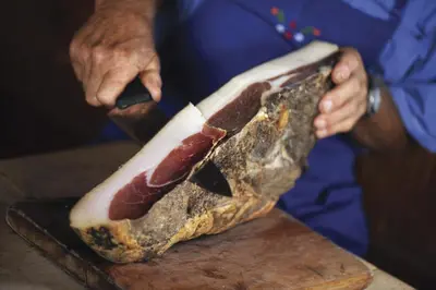 a person holding a hot dog on a cutting board at Hotel Garni Lichtenau in Schenna