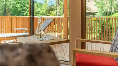 a wooden table with glasses on a porch at Hotel Weihrerhof in Soprabolzano