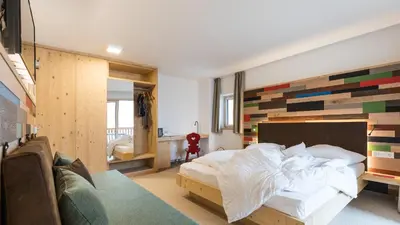 a bedroom with a bed with a wooden accent wall at Hotel Weihrerhof in Soprabolzano
