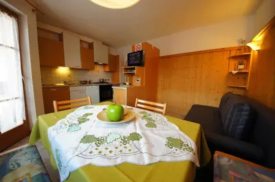 a table with a plate with an apple on it at Gasthof La Pli Apartments in San Vigilio Di Marebbe