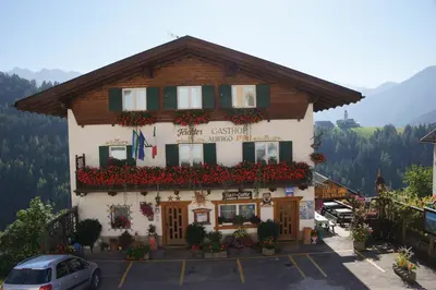 a building with flowers in front of it at Gasthof La Pli Apartments in San Vigilio Di Marebbe