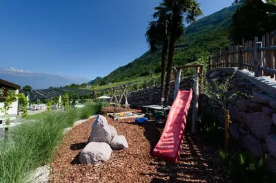a playground with a red slide and a rock wall at Moar Lodge in Postal