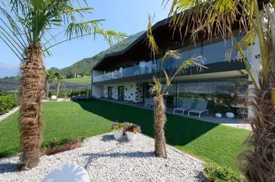 a house with palm trees in front of it at Moar Lodge in Postal