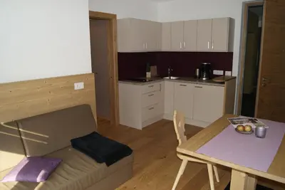 a living room and kitchen with a couch and a table at Apartment 39012 in Merano