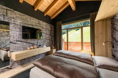 a living room with a couch and a tv at Hotel Jaufentalerhof in Racines