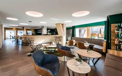 a restaurant with chairs and tables and a bar at Hotel Jaufentalerhof in Racines