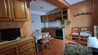 a small kitchen with a table and a kitchen with a stove at Residence Marmolada in Rocca Pietore