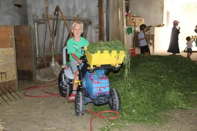 a young boy riding a toy bike with a trailer at Spisserhof in Chiusa