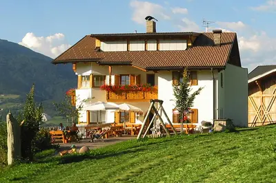 a house on a hill with a grassy field at Spisserhof in Chiusa