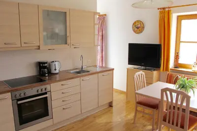 a kitchen with a sink and a table and a tv at Spisserhof in Chiusa