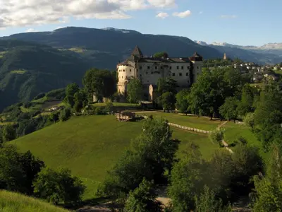 a castle on a hill with a green field at Residence Perwanger in Fiè