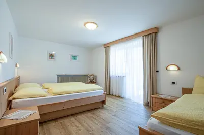 a bedroom with two beds and a window at Residence Crazzolara in La Villa
