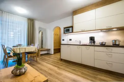a kitchen with a table and a dining room at Residence Crazzolara in La Villa