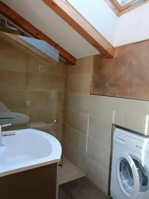 a bathroom with a washing machine and a sink at Fiemme Deluxe Apartment in Castello di Fiemme