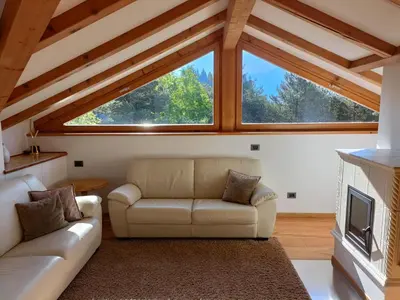 a living room with a couch and a fireplace at Fiemme Deluxe Apartment in Castello di Fiemme