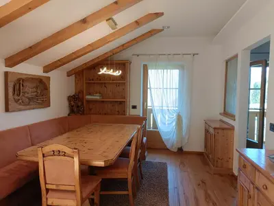 a dining room with a table and a couch at Fiemme Deluxe Apartment in Castello di Fiemme