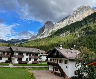 a group of buildings in front of a mountain at Arnica in Canazei