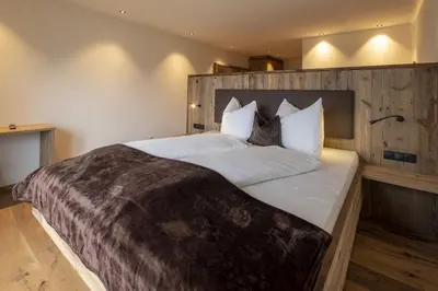a bedroom with a large bed with a wooden headboard at Platiederhof in Laion