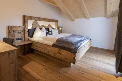 a bedroom with a large bed with a wooden frame at Platiederhof in Laion