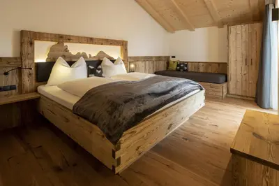 a bedroom with a large bed with a wooden headboard at Platiederhof in Laion