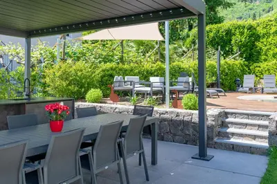 a patio with a table and chairs and an umbrella at Ferienwohnungen Atz in Termeno