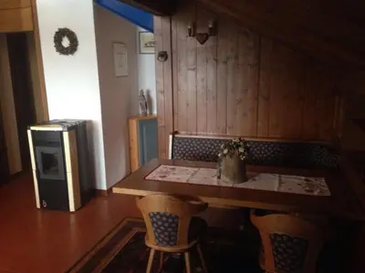 a kitchen with a table and chairs and a refrigerator at Villa San Martino in San Martino di Castrozza