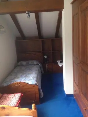 a bedroom with a bed with a wooden headboard at Villa San Martino in San Martino di Castrozza