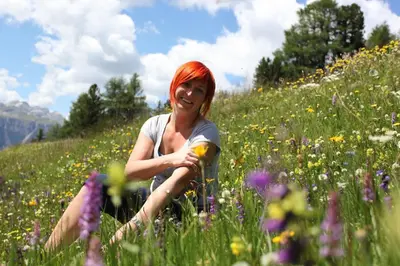 a woman with red hair sitting in a field of flowers at Casa Serac´ in La Valle