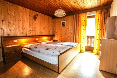 a bedroom with a bed in a wooden room at Casa Serac´ in La Valle