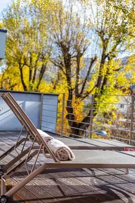a wooden chair sitting on top of a patio at Kronplatz LOFT Bruneck in Brunico