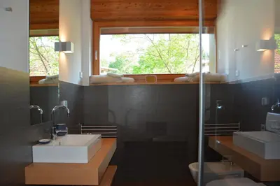 a bathroom with a sink and a glass shower at Kronplatz LOFT Bruneck in Brunico
