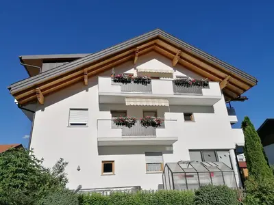 a white building with flower boxes on the balconies at Appartements Oberleiter in Valdaora