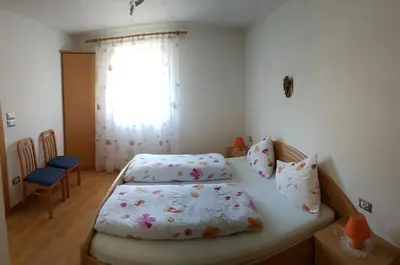 a small bedroom with a bed and a window at Appartements Oberleiter in Valdaora