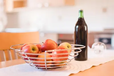 a bowl of apples on a table with a bottle of wine at Brugger Hof in Feldthurns