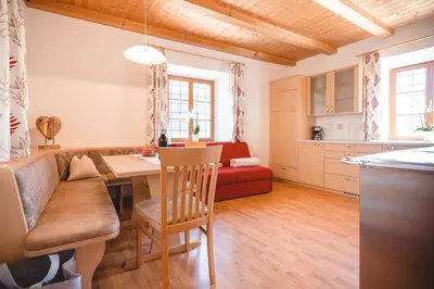 a kitchen and living room with a table and a couch at Brugger Hof in Feldthurns