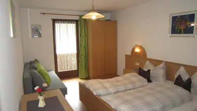 a living room with a bed and a couch at Ferienhaus-Grünfelder in Luson