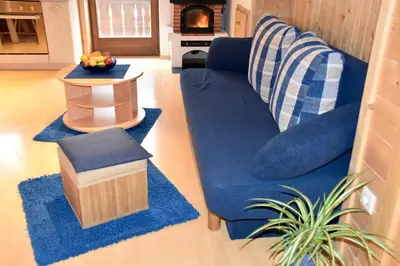 a living room with a blue couch and blue rugs at Ferienhaus-Grünfelder in Luson