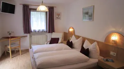 a hotel room with two beds and a table at Ferienhaus-Grünfelder in Luson