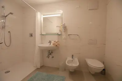 a bathroom with a shower and a sink and a toilet at Hotel Stampfer B&B in Laives