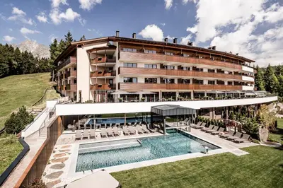 a swimming pool in a building with snow covered trees at Josef Mountain Resort in Avelengo