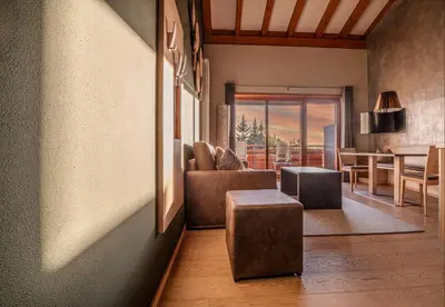a kitchen and living room with a black couch at Josef Mountain Resort in Avelengo