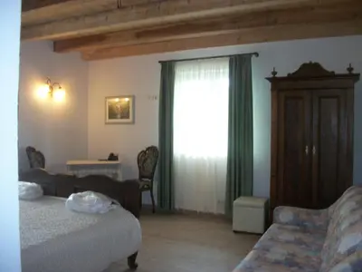 a bedroom with a bed and a window with green curtains at Agri-park Casa Miramonte in Ronzone