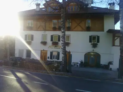 a large white building with the sun shining on it at Agri-park Casa Miramonte in Ronzone
