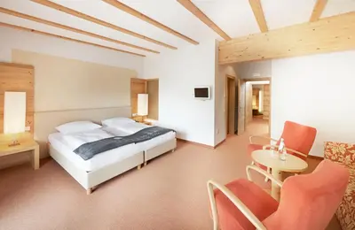 a bedroom with a bed and a table and chairs at Vegan Hotel La Vimea in Naturno